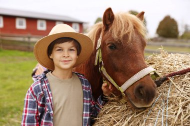 At destekli terapi. Dışarıda saman yığınının yanında midillisi olan güzel bir çocuk. Sevimli evcil hayvan