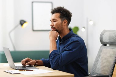 ofiste masada dizüstü bilgisayarda çalışan adam