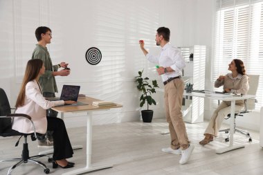 Bir grup meslektaşım ofiste dart oynuyor.