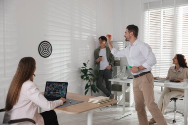 Bir grup meslektaşım ofiste dart oynuyor.