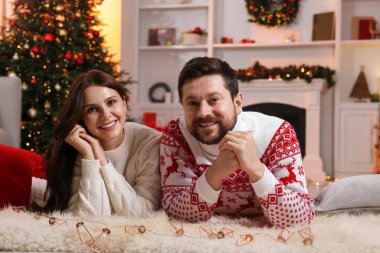 Mutlu çift Noel için dekore edilmiş odada birlikte vakit geçiriyor.