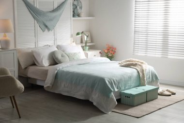 Büyük yataklı, yastıklı ve lambalı şık bir yatak odası. İç tasarım