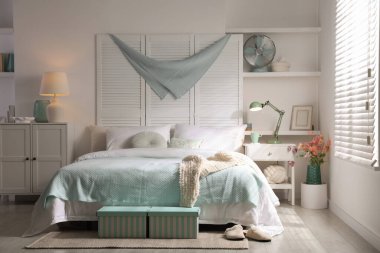 Büyük yataklı, yastıklı ve lambalı şık bir yatak odası. İç tasarım