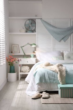 Büyük yataklı, yastıklı ve lambalı şık bir yatak odası. İç tasarım