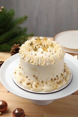 Hafif ahşap masada Noel dekoru olan lezzetli bir pasta, yakın plan.