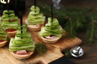 Noel ağaçları salatalıktan, kırmızı havyardan, jambondan ve ahşap masadaki şenlikli dekordan yapılır.