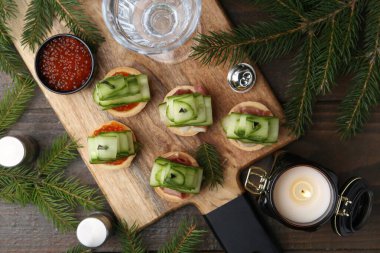 Noel ağaçları salatalıktan, kırmızı havyardan, jambondan ve ahşap masa üzerindeki şenlikli dekordan yapılmıştır.