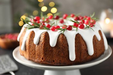 Bulanık ışıklara karşı kremalı, kızılcıklı ve biberiyeli lezzetli bir Noel pastası.