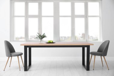 Masa ve sandalyeler büyük pencerenin yanında. İç tasarım