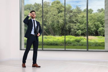 Büyük pencereli boş odada emlakçı