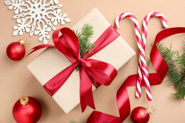 Firavun ağacı dalları, hediye, baston şekerler ve bej arka planda Noel dekoru, düz uzanma