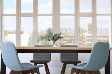 Masa ve sandalyeler büyük pencerenin yanında. İç tasarım