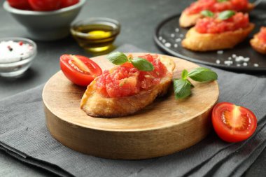 Siyah masada servis edilen domatesli ve fesleğenli lezzetli bruschettalar.