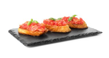 Domatesli lezzetli bruschettalar ve beyaz üzerine izole edilmiş fesleğenler.