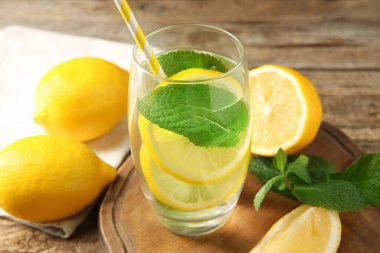 Limonlu ve nane şekerli suyu ahşap masaya serpiştiriyorum. Yakın plan.