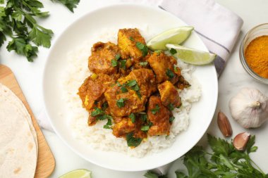 Beyaz mermer masada servis edilen pirinçli tavuk tikka masala.