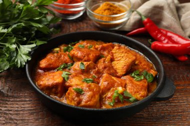 Ahşap masada baharatlı tavuk tikka masala, yakın plan.
