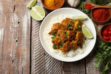 Lezzetli tavuk tikka masala, pirinç, maydanoz, kireç ve baharatlar ahşap masa, düz yatak. Metin için boşluk