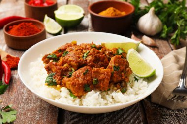 Lezzetli tavuk tikka masala pirinç, maydanoz ve limon renkli ahşap masa, yakın plan