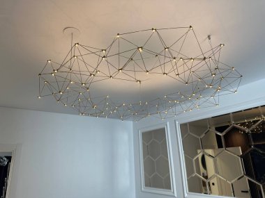 Odanın beyaz tavanında şık bir avize.