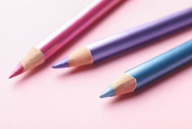 Pembe arka planda parlak göz kalemleri, yakın plan.