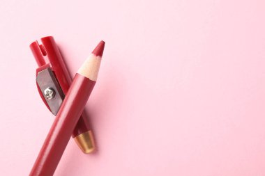 Kırmızı göz kalemi ve pembe arka planda keskinleştirici, üst manzara. Metin için boşluk