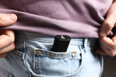 Cebinde gizli kamera olan bir adam, yakın plan.