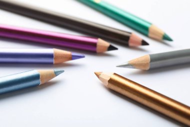 Beyaz arkaplanda renkli göz kalemleri, yakın plan