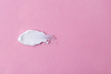 Pembe arka planda nemlendirici krem örneği. Metin için boşluk