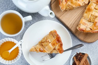 Lezzetli ev yapımı elmalı turta, baharatlar ve çay gri desenli masa, düz uzanma