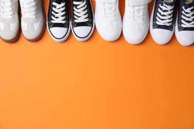 Turuncu arka planda bir sürü şık çocuk ayakkabısı var. Metin için boşluk