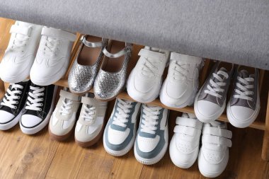 Ahşap zemin üzerinde farklı çocuk ayakkabıları olan depo tezgahı.