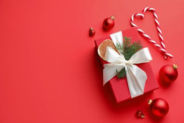 Noel hediyesi, süsler ve kırmızı arka planda şeker kamışları, düz yatış. Metin için boşluk