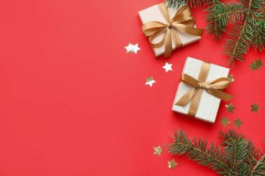 Firavun ağacı dalları, hediyeler ve kırmızı arka planda Noel süsü, düz bir zemin. Metin için boşluk