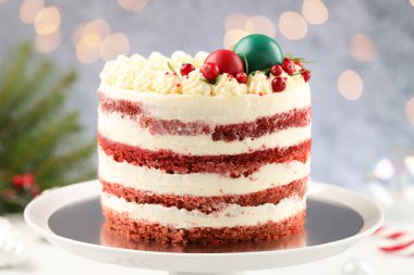 Noel dekoru ve kırmızı üzümlü enfes sünger kek bulanık gri arka planda duruyor, yakın plan. Bokeh etkisi