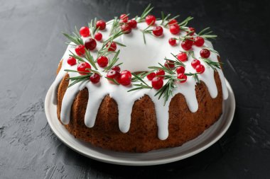 Kremalı, yaban mersinli ve biberiyeli lezzetli bir Noel pastası, yakın plan.