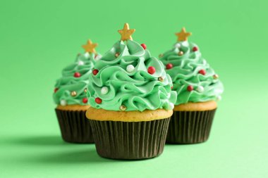 Yeşil arka planda Noel ağacı şekilli kekler, yakın plan.