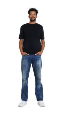 Beyaz arka planda şık kot giyen mutlu bir adam.