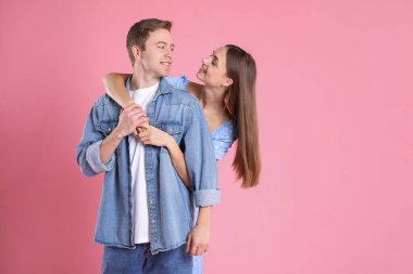 Pembe arka planda kucaklaşan sevimli bir çift, mesaj için yer var. Romantik randevu