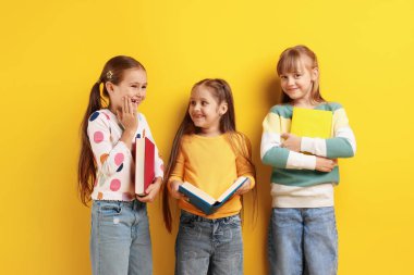 Turuncu arka plan kitapları olan sevimli çocuklar.