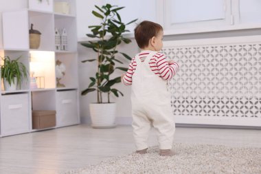 İlk adımlar. Sevimli küçük bebek. Evinde yerde yürüyor.