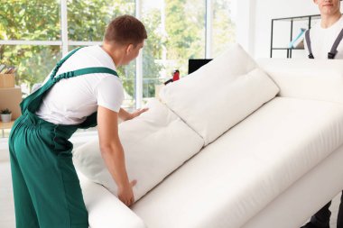 Taşınma günü. Yeni ofisinde şık kanepesi olan işçiler