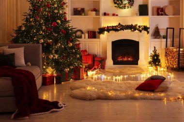 Noel ağacı, şömine ve şenlikli dekorlu şık bir oda. İç tasarım