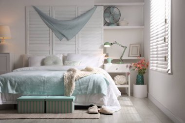 Büyük yataklı, yastıklı ve lambalı şık bir yatak odası. İç tasarım