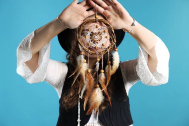 Açık mavi arka planda güzel bir düş kapanı olan, seçici odaklı bir kadın.