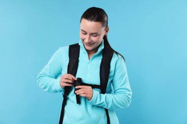 Gizli kamera ve açık mavi arka planda sırt çantası olan bir turist.