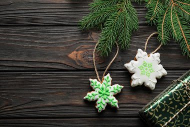 Lezzetli zencefilli kurabiyeler, hediye kutusu ve tahta masanın üzerinde köknar ağacı dalları. Metin için boşluk