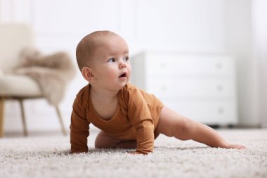 Evde yerde yatan şirin bir bebeğin portresi.