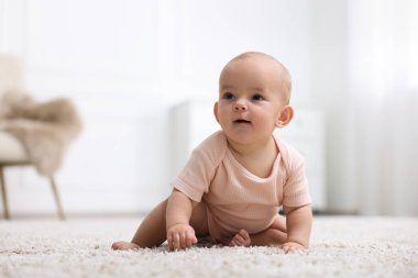 Evde yerde yatan şirin bir bebeğin portresi.