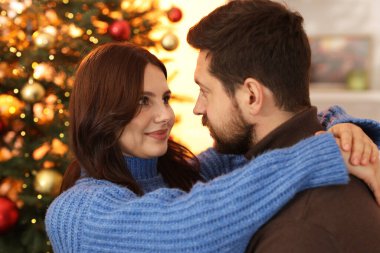 Mutlu çift Noel için dekore edilmiş odada birlikte vakit geçiriyor.